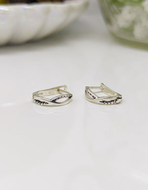 Елегантни дамски обеци с минималистичен дизайн във формата на преплетени халки или стилизиран символ на безкрайнос, изработени от сребро с проба 925