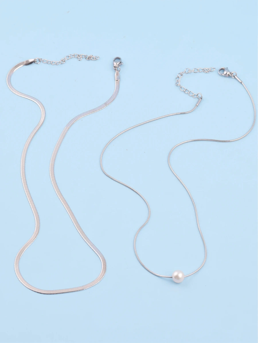 Комплект елегантни и стилни колиета образуващи двойно дамско колие. Колиетата са с различни плетки и дължини. Едно от колиетата е декорирано с изкуствена перла. Изработени от висококачествена неръждаема стомана 316L в цвят сребро. Двете колиета може да се носи и по отделно.