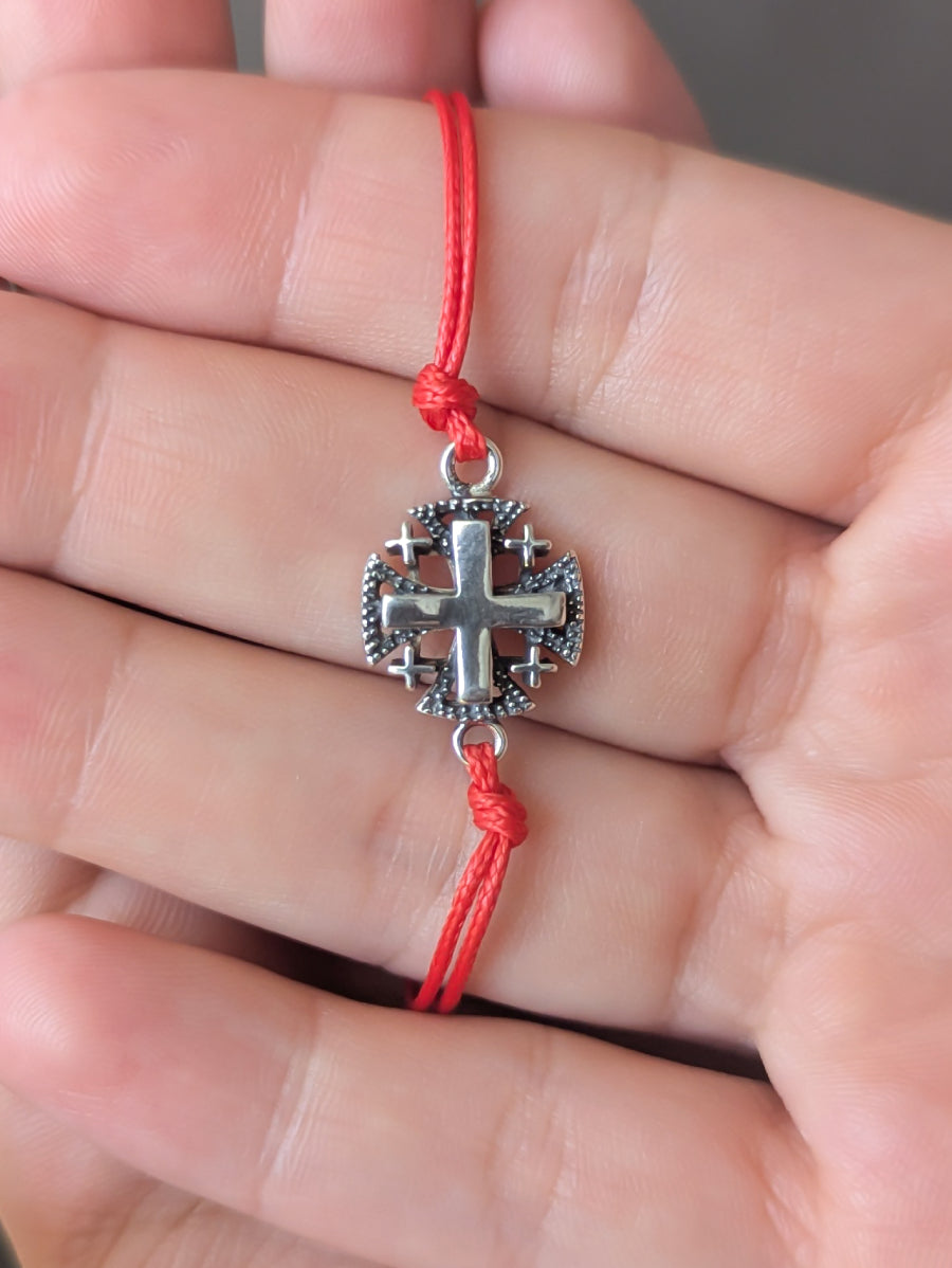 Гривна с червен конец и сребърно кръстче.