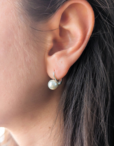 Сребърни дамски обеци с бели синтетични перли и с английско закопчаване.