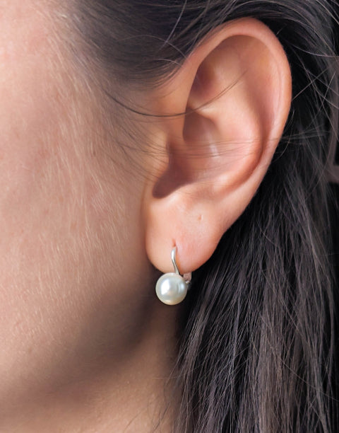 Сребърни дамски обеци с бели синтетични перли и с английско закопчаване.