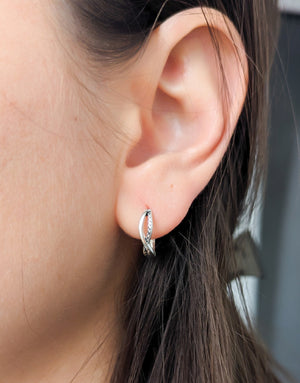 Елегантни дамски обеци с минималистичен дизайн във формата на преплетени халки или стилизиран символ на безкрайнос, изработени от сребро с проба 925