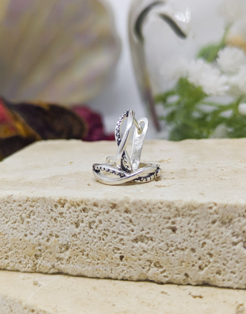 Елегантни дамски обеци с минималистичен дизайн във формата на преплетени халки или стилизиран символ на безкрайнос, изработени от сребро с проба 925