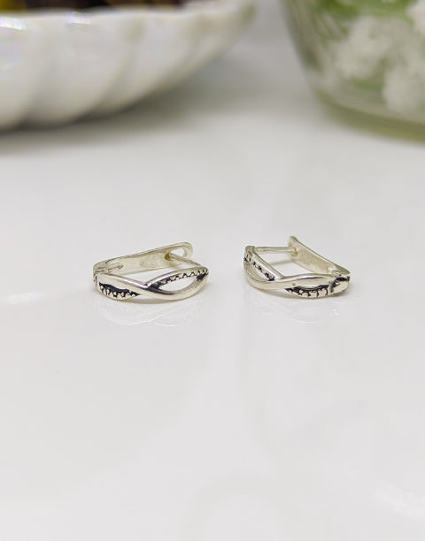 Елегантни дамски обеци с минималистичен дизайн във формата на преплетени халки или стилизиран символ на безкрайнос, изработени от сребро с проба 925