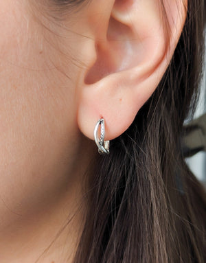 Елегантни дамски обеци с минималистичен дизайн във формата на преплетени халки или стилизиран символ на безкрайнос, изработени от сребро с проба 925