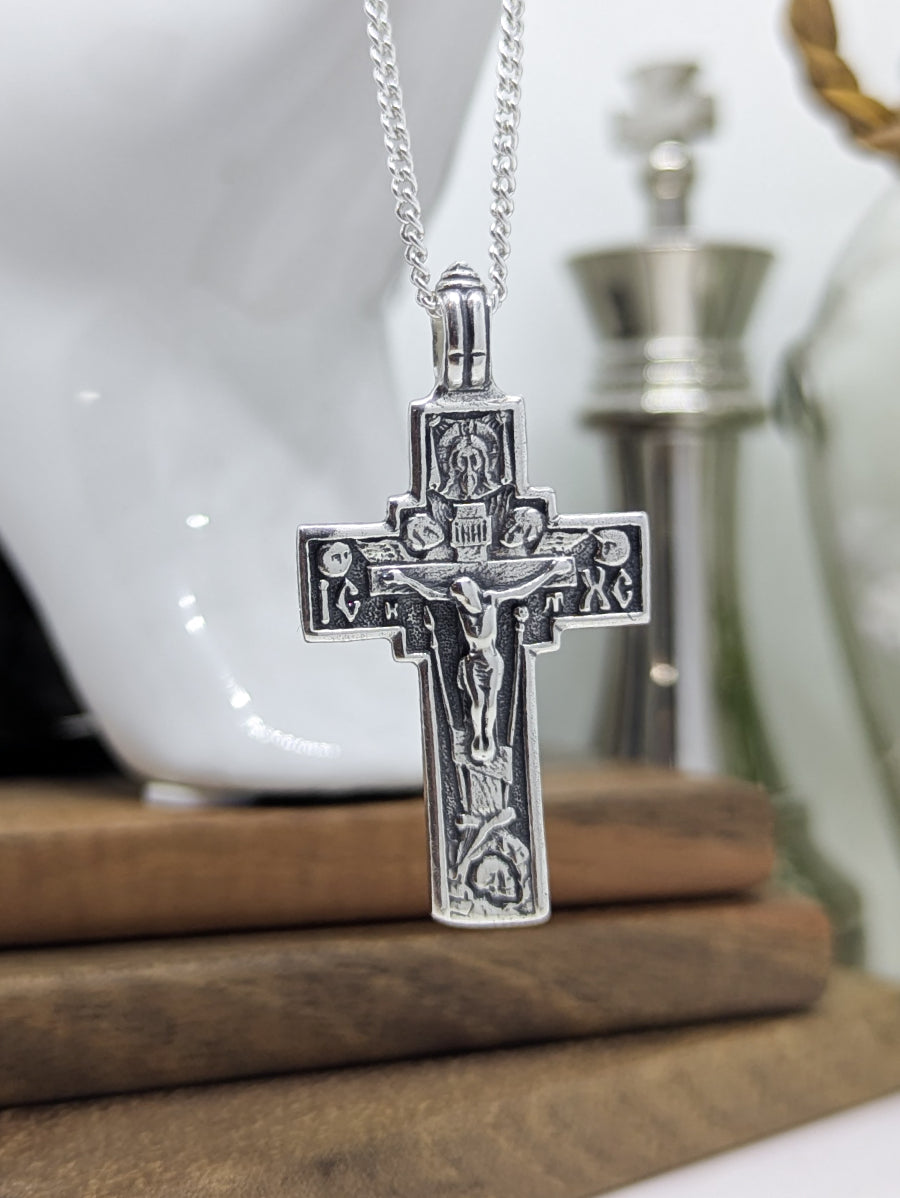 Сребърен православен кръст 925 с високо релефно изображение на Разпятието Христово и IC XC – лицева страна на двулицев медальон, оксидирано сребро.