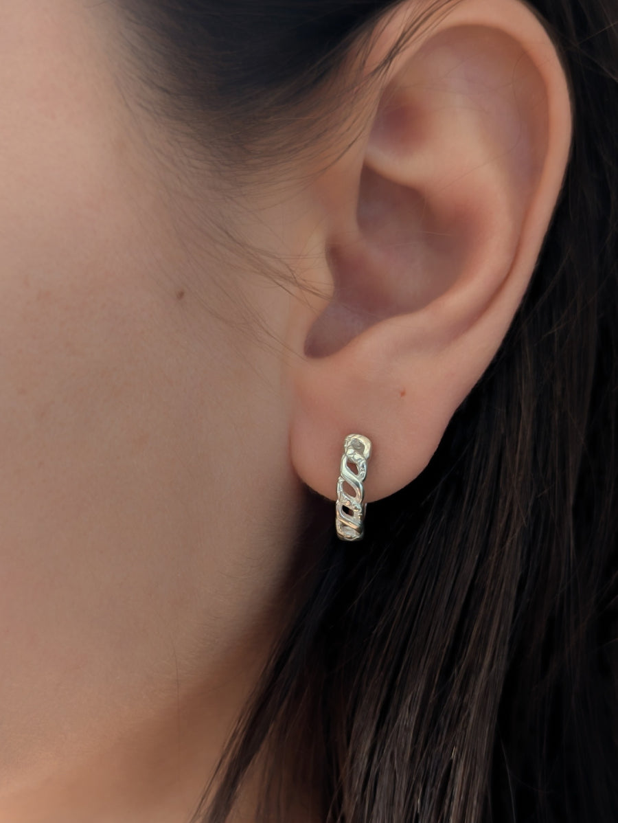 Малки сребърни обеци тип халки (huggie) проба 925 с плътен, изрязан дизайн, имитиращ верига или преплетени звена, носени на ухото